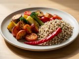 Assiette équilibrée composée de légumes colorés, de céréales et de piments rouges frais, photographiée à la lumière naturelle.